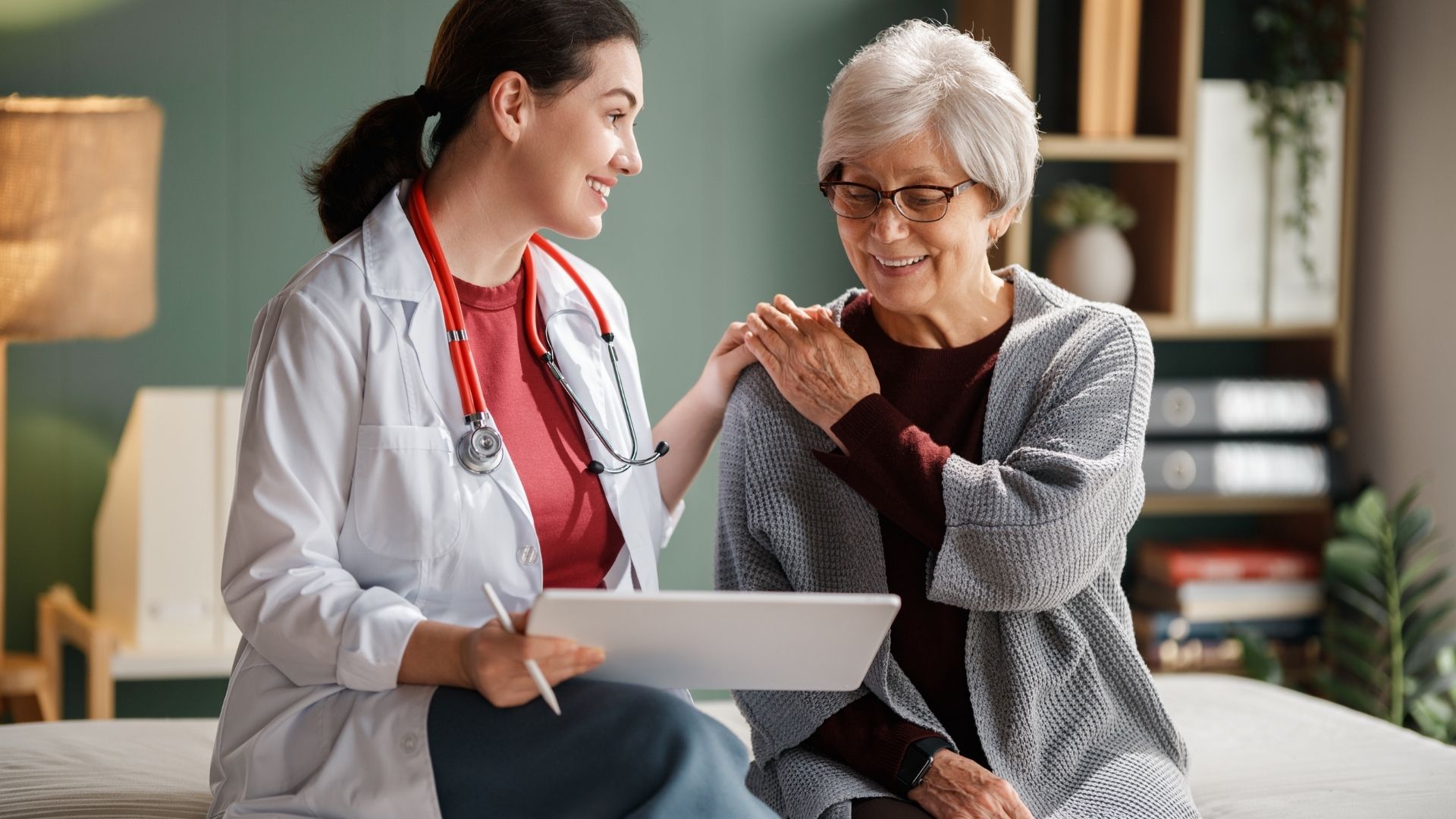 A clinician reviewing a tablet with an older patient