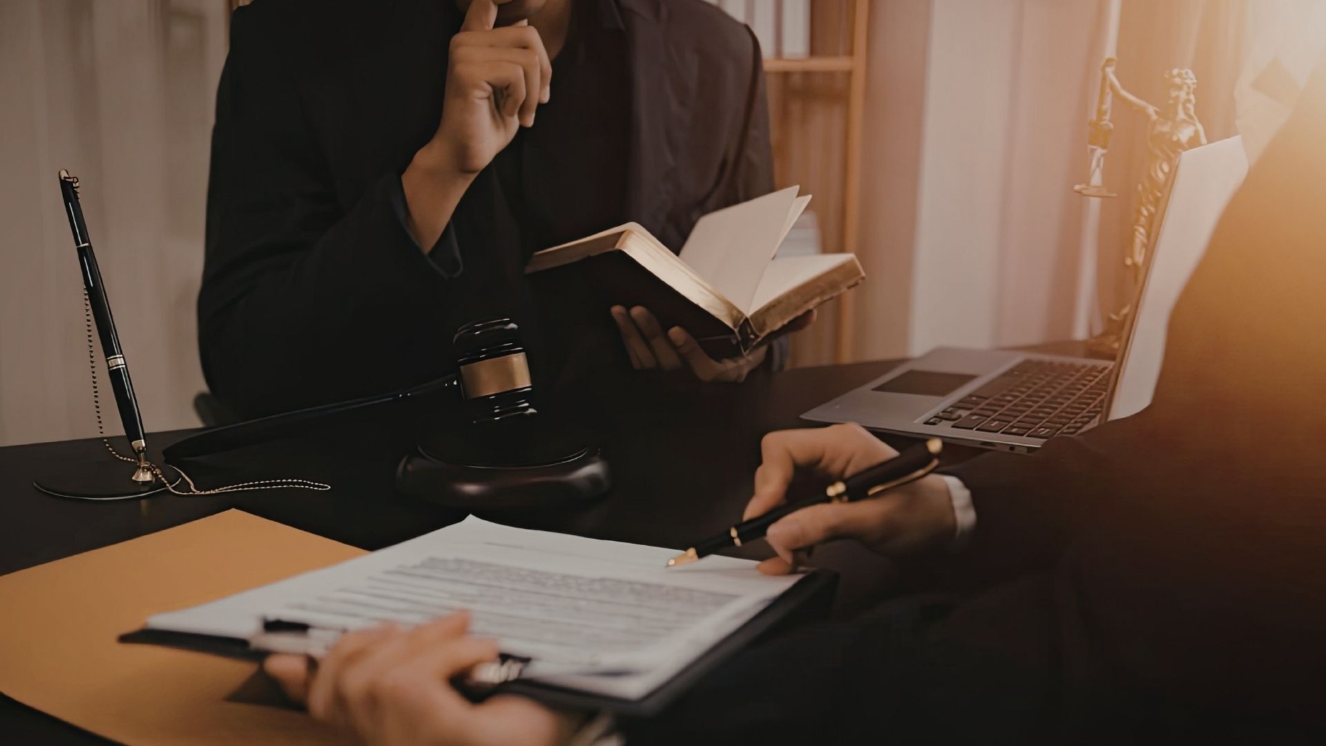 A legal consultation at a desk with documents and a gavel